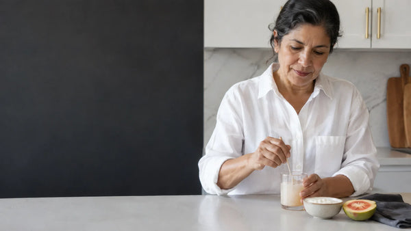 Mujer adulta preparando una bebida junto a su desayuno. Imagen editorial generada con IA.