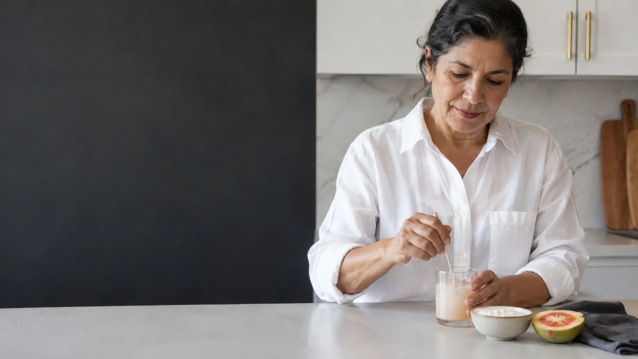 Mujer adulta preparando una bebida junto a su desayuno. Imagen editorial generada con IA.